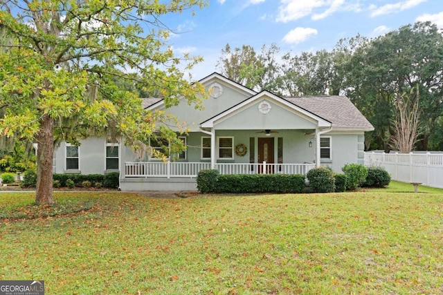 single story home featuring a porch, ceiling fan, and a front lawn