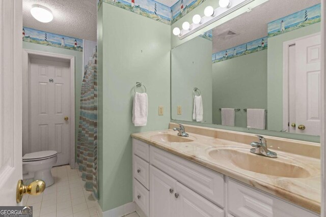 bathroom featuring tile patterned floors, vanity, toilet, and a textured ceiling