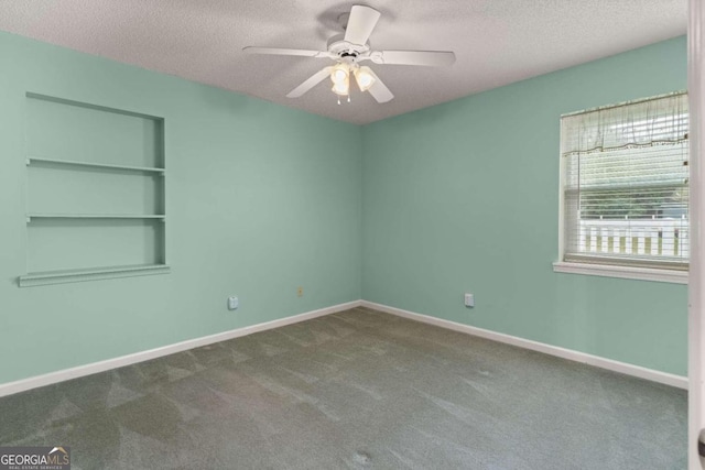 carpeted empty room featuring ceiling fan and a textured ceiling