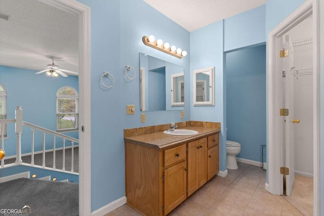 bathroom featuring ceiling fan, tile patterned floors, a textured ceiling, toilet, and vanity