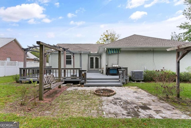 back of property featuring a pergola, a wooden deck, central air condition unit, and a fire pit