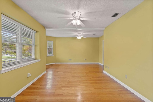 unfurnished room with ceiling fan, light hardwood / wood-style floors, and a textured ceiling