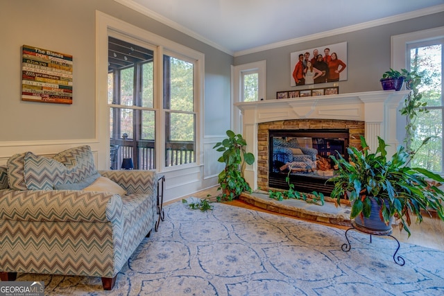 sitting room featuring a fireplace, wood-type flooring, a wealth of natural light, and crown molding