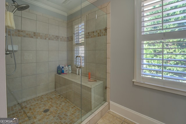 bathroom featuring a shower with door, plenty of natural light, and ornamental molding