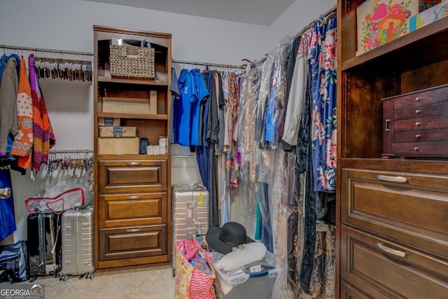 walk in closet featuring light colored carpet