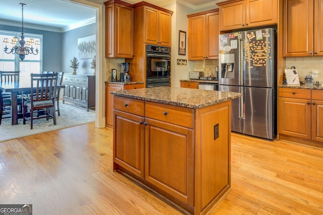 kitchen featuring a center island, oven, stainless steel refrigerator with ice dispenser, light wood-type flooring, and a notable chandelier