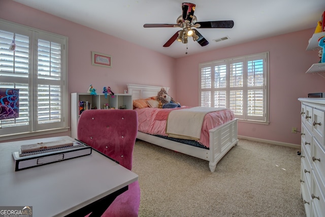 bedroom featuring multiple windows, ceiling fan, and light carpet