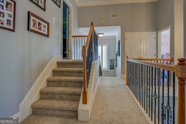 stairway featuring carpet, ornamental molding, and a towering ceiling