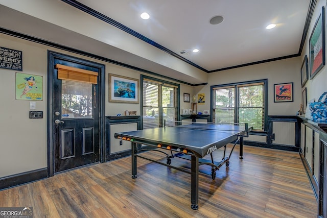 recreation room with hardwood / wood-style flooring and crown molding