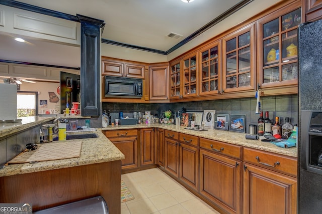 kitchen featuring sink, light stone counters, crown molding, decorative backsplash, and light tile patterned flooring