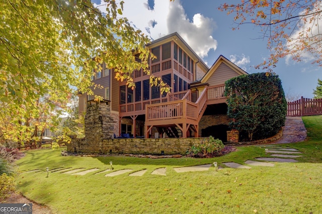 back of property with a yard and a wooden deck