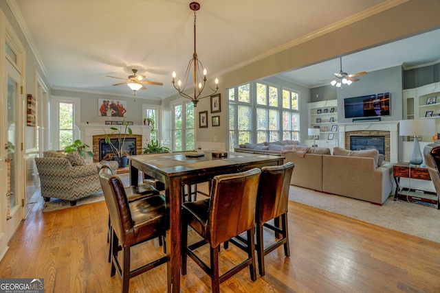 dining area with plenty of natural light, crown molding, and light hardwood / wood-style flooring