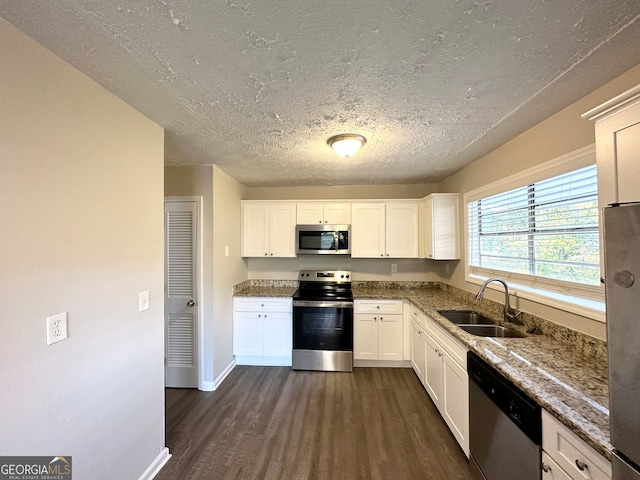 kitchen with stone counters, sink, stainless steel appliances, dark hardwood / wood-style flooring, and white cabinets