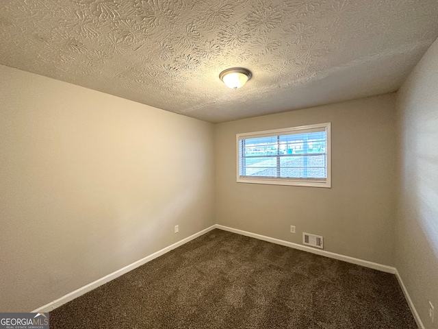 empty room with carpet flooring and a textured ceiling