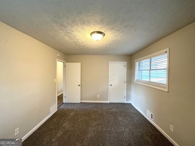 unfurnished bedroom featuring carpet and a textured ceiling