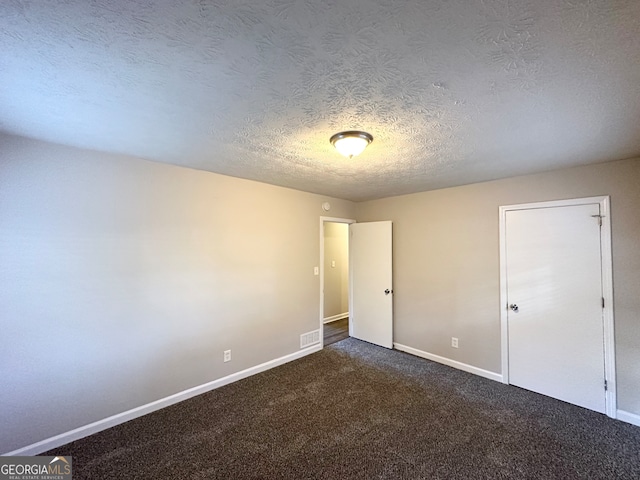 unfurnished bedroom featuring dark colored carpet and a textured ceiling