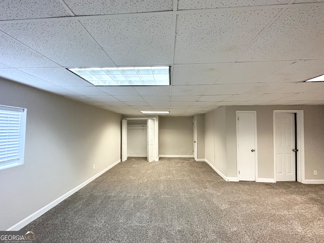 basement featuring carpet floors and a paneled ceiling