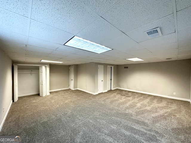 basement featuring carpet flooring and a drop ceiling