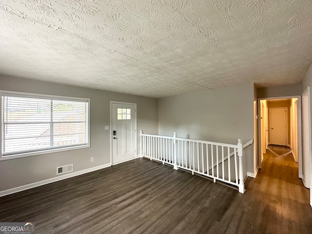 entryway with a textured ceiling and dark hardwood / wood-style floors