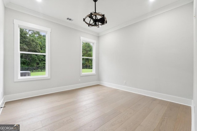 unfurnished room with light hardwood / wood-style floors, plenty of natural light, and crown molding