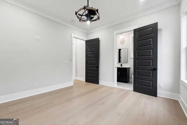 unfurnished bedroom featuring light wood-type flooring and crown molding