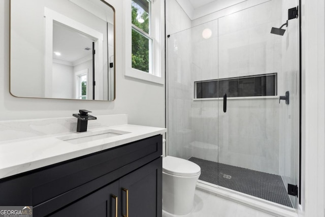 bathroom with vanity, toilet, a shower with shower door, and ornamental molding