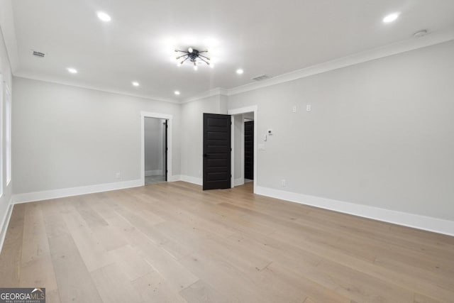 spare room featuring crown molding and light hardwood / wood-style flooring