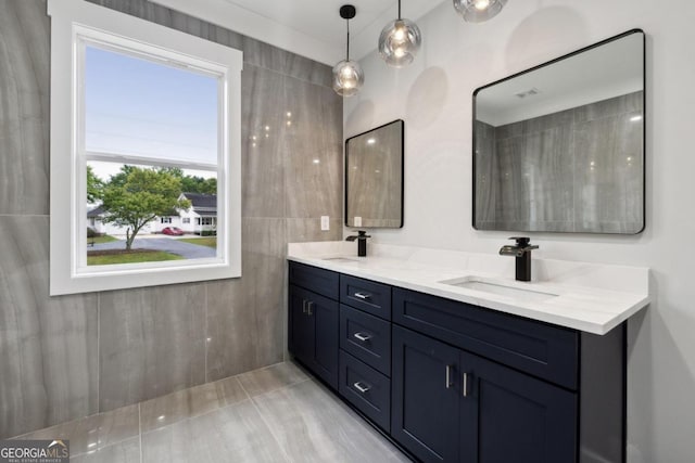 bathroom featuring vanity and tile walls