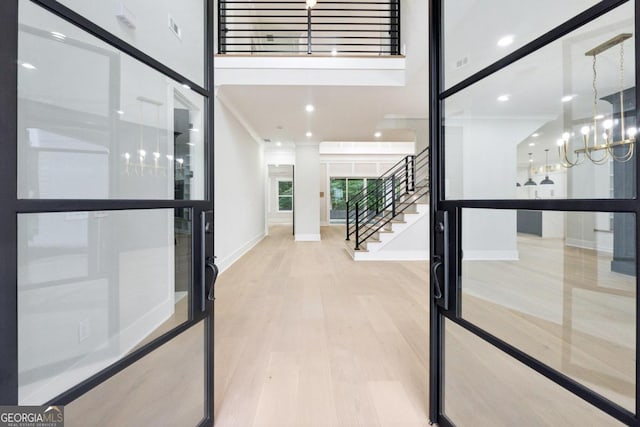 foyer with a chandelier and light wood-type flooring