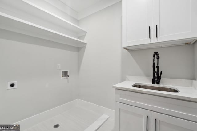 laundry area with electric dryer hookup, hookup for a washing machine, sink, and cabinets