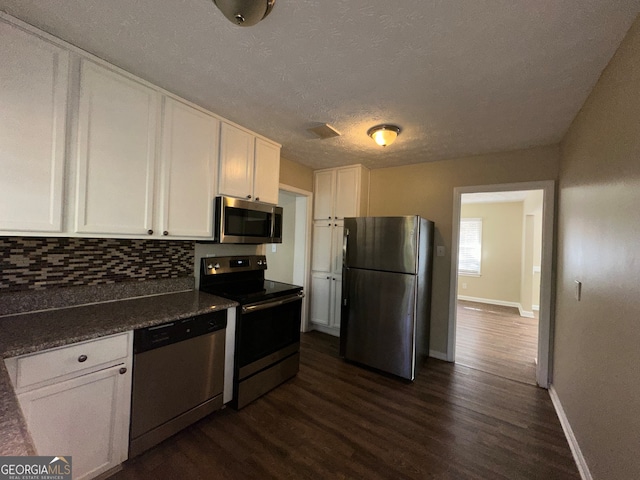 kitchen featuring white cabinets, decorative backsplash, dark hardwood / wood-style flooring, and appliances with stainless steel finishes