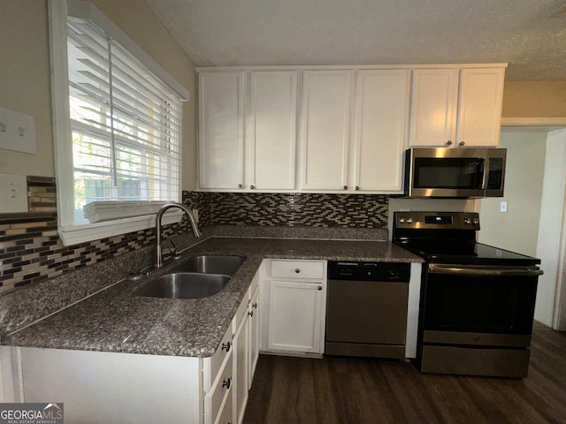 kitchen featuring dark hardwood / wood-style flooring, white cabinetry, sink, and appliances with stainless steel finishes