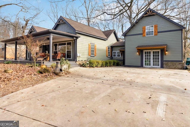 rear view of house with covered porch and french doors