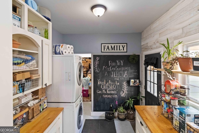 washroom with wooden walls and stacked washer and clothes dryer