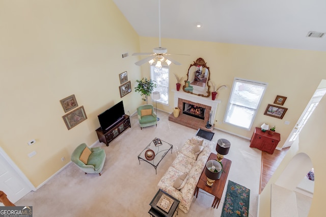 carpeted living room with visible vents, a fireplace, baseboards, and ceiling fan