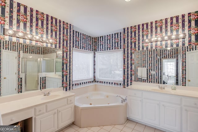 full bath featuring a jetted tub, wallpapered walls, a sink, and tile patterned floors