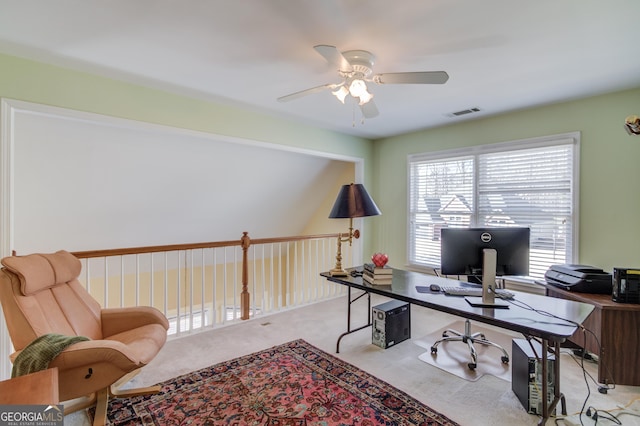 office space featuring light carpet, visible vents, and a ceiling fan