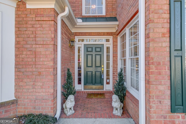 view of exterior entry with brick siding