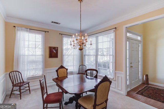 dining room featuring ornamental molding, a healthy amount of sunlight, visible vents, and an inviting chandelier