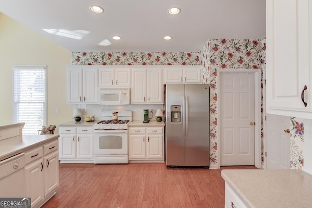 kitchen featuring light countertops, white appliances, light wood-type flooring, and white cabinetry