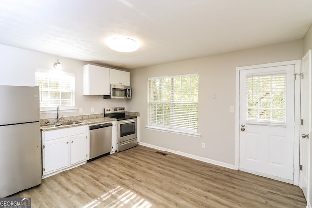 kitchen with appliances with stainless steel finishes, a healthy amount of sunlight, and sink