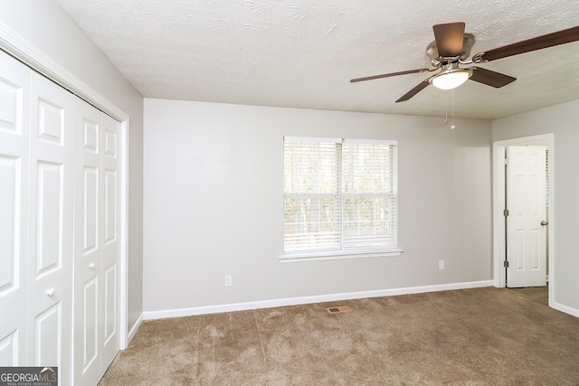 unfurnished bedroom with ceiling fan, light carpet, and a closet