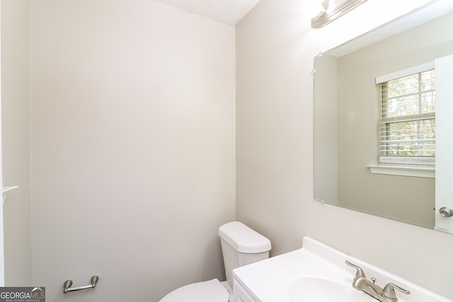 bathroom with vanity, a textured ceiling, and toilet