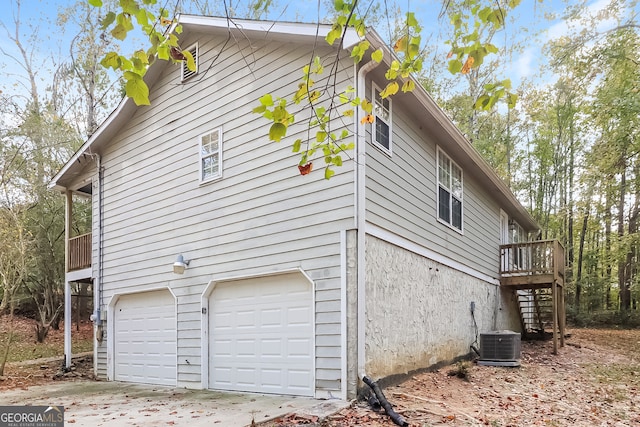 view of side of home with a garage and cooling unit