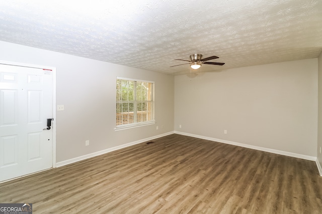 interior space featuring ceiling fan, dark hardwood / wood-style flooring, and a textured ceiling