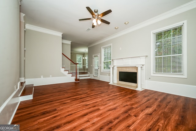 unfurnished living room featuring ceiling fan with notable chandelier, wood-type flooring, and ornamental molding