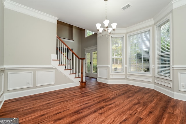 unfurnished dining area with a notable chandelier, a healthy amount of sunlight, crown molding, and dark wood-type flooring