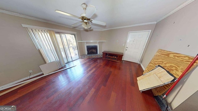 living room featuring a fireplace, ceiling fan, crown molding, and dark wood-type flooring