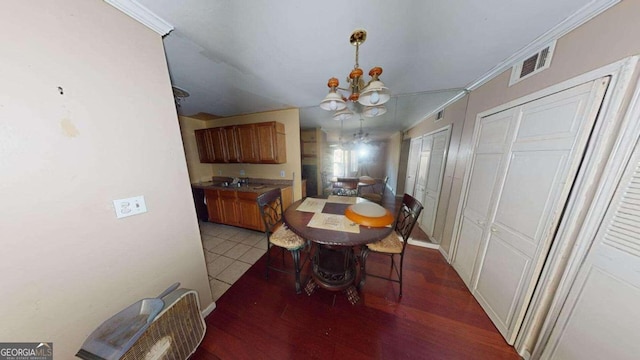 dining area featuring hardwood / wood-style floors, a notable chandelier, and ornamental molding