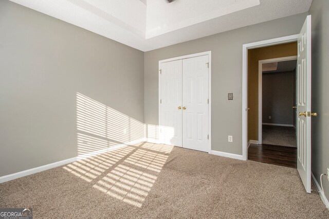 unfurnished bedroom with carpet flooring, a textured ceiling, and a closet